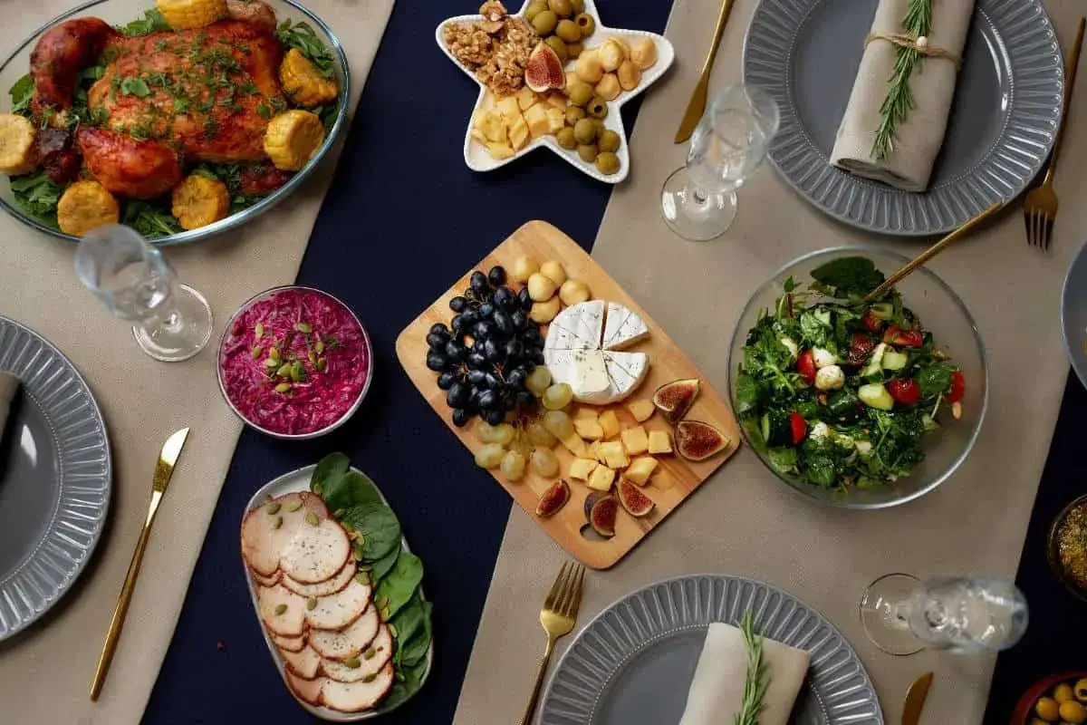 Un festin prêt pour un menu de baptême à préparer la veille : poulet rôti, salade, plateau de fromages et charcuterie.
