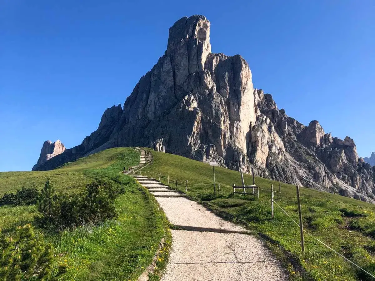 Sentiero che sale verso imponenti vette rocciose, ideale per **passo Giau escursioni**.