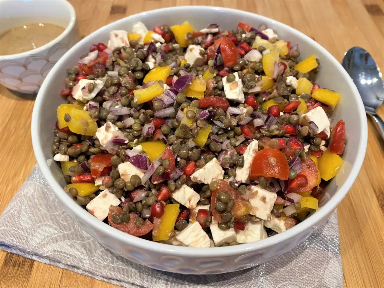 Salade colorée de lentilles, feta, poivrons jaunes, tomates et oignons rouges. Un délice frais et sain.