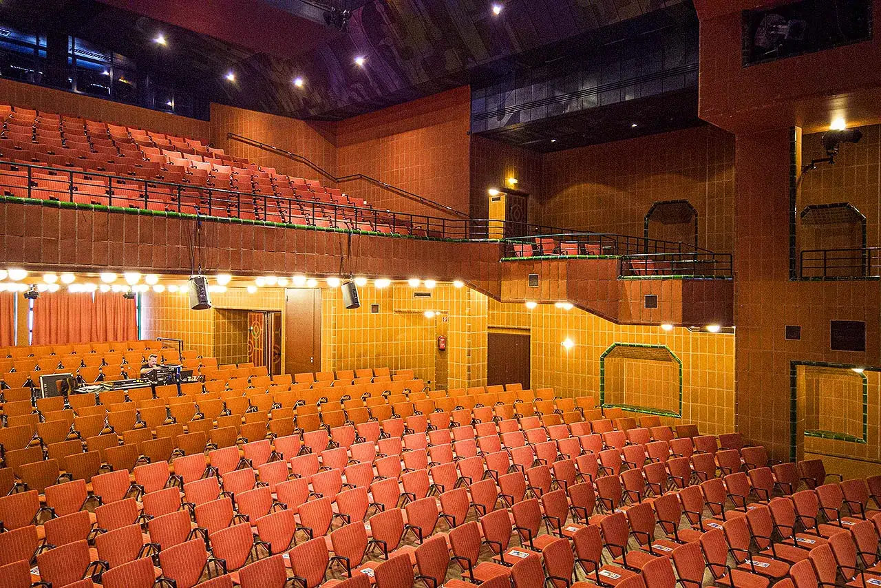 Leere R&auml;nge im Theater, bereit f&uuml;r das bergischer l&ouml;we programm. Orange Sitze und warme Wandfliesen schaffen Atmosph&auml;re.