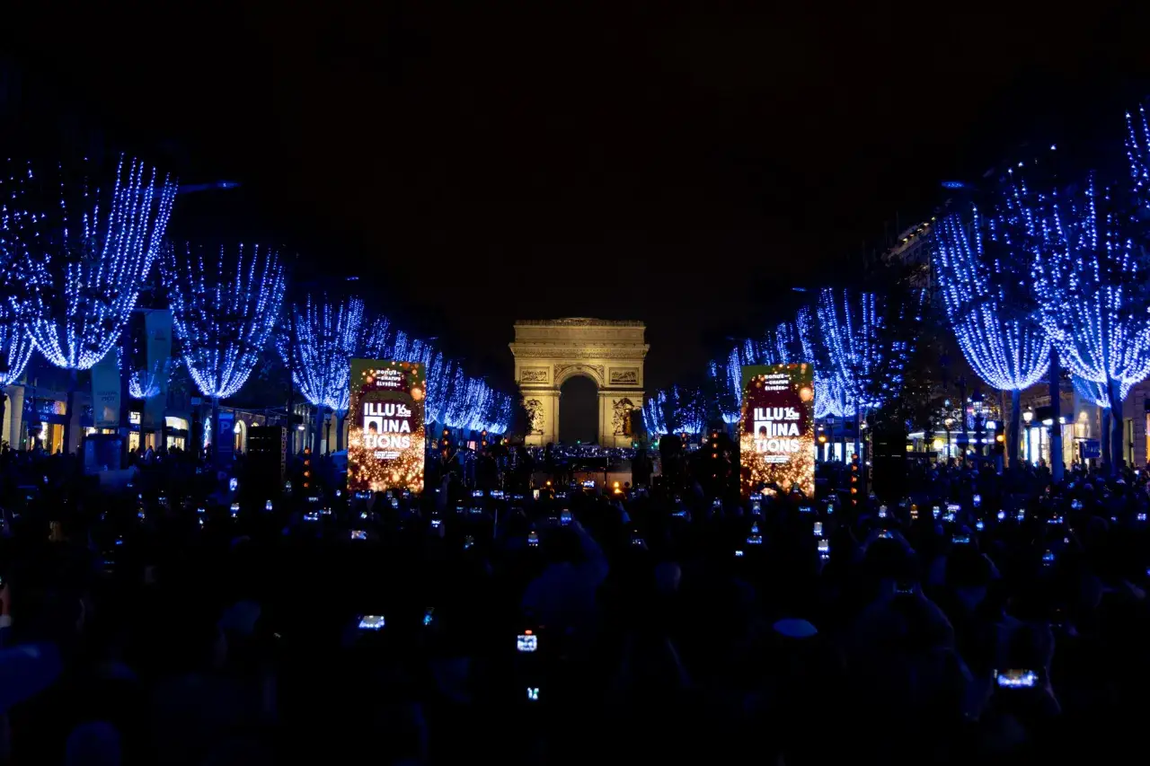 Illuminations des Champs-Élysées, une foule en liesse filme le spectacle. Idéal pour savoir que faire à Paris en novembre.