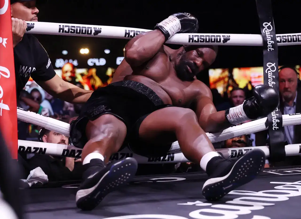 Ciężko znokautowany Dillian Whyte opiera się o liny ringu, wyczerpany. Wilder Chisora w akcji.