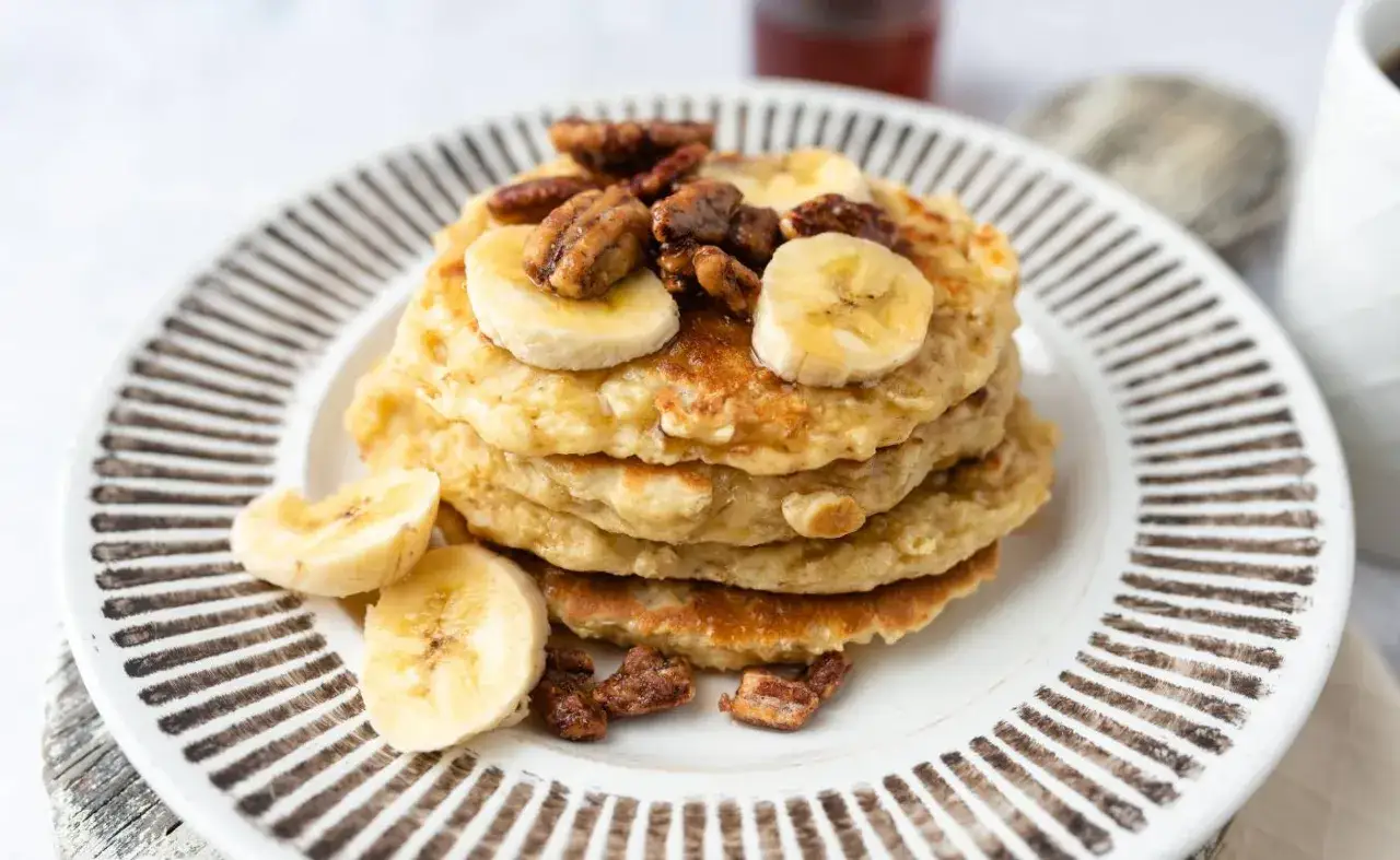 Pile de pancakes muesli aux bananes et noix de pécan, un petit-déjeuner gourmand et sain.