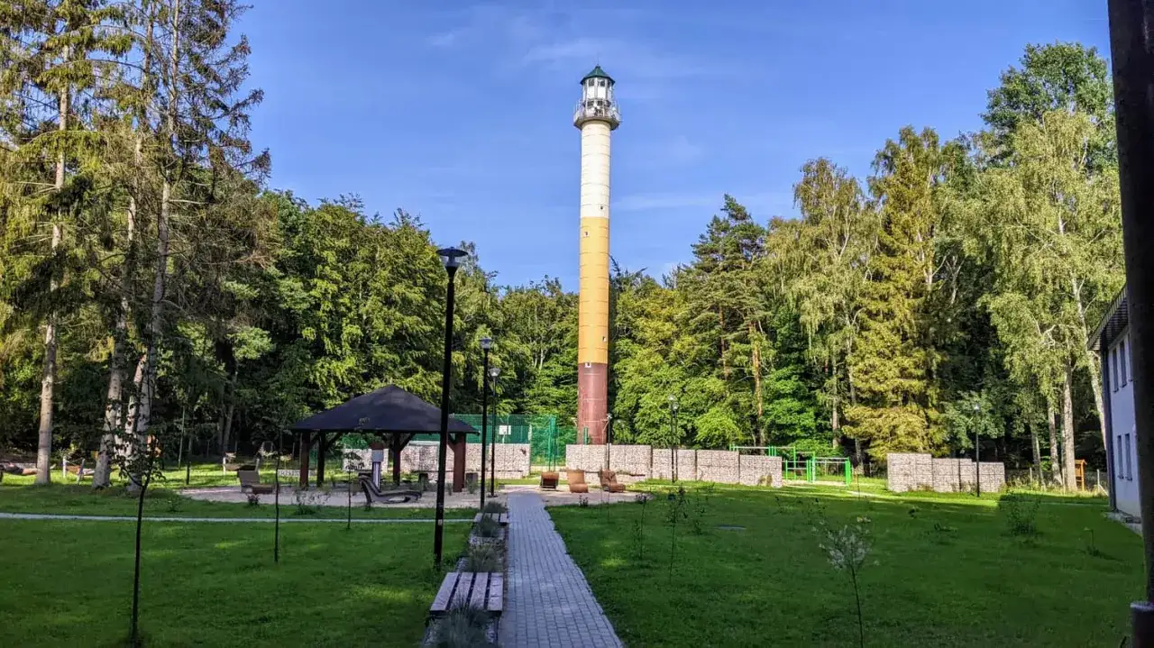 Wysoka wieża widokowa Orzechowo, otoczona zielenią, z placem zabaw i miejscami do odpoczynku.