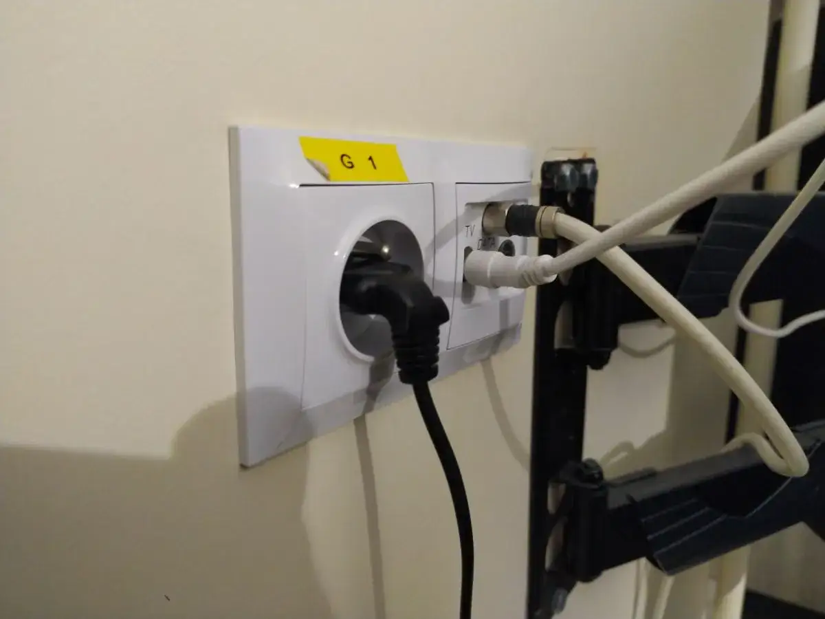 Telewizor na ścianie z zagiętym kablem antenowym