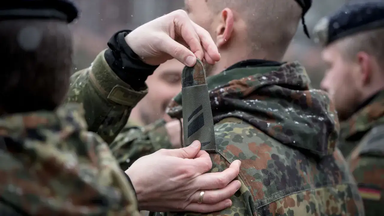 Schulterklappen der Bundeswehr werden angelegt. Ein Soldat erhält neue Dienstgradabzeichen.