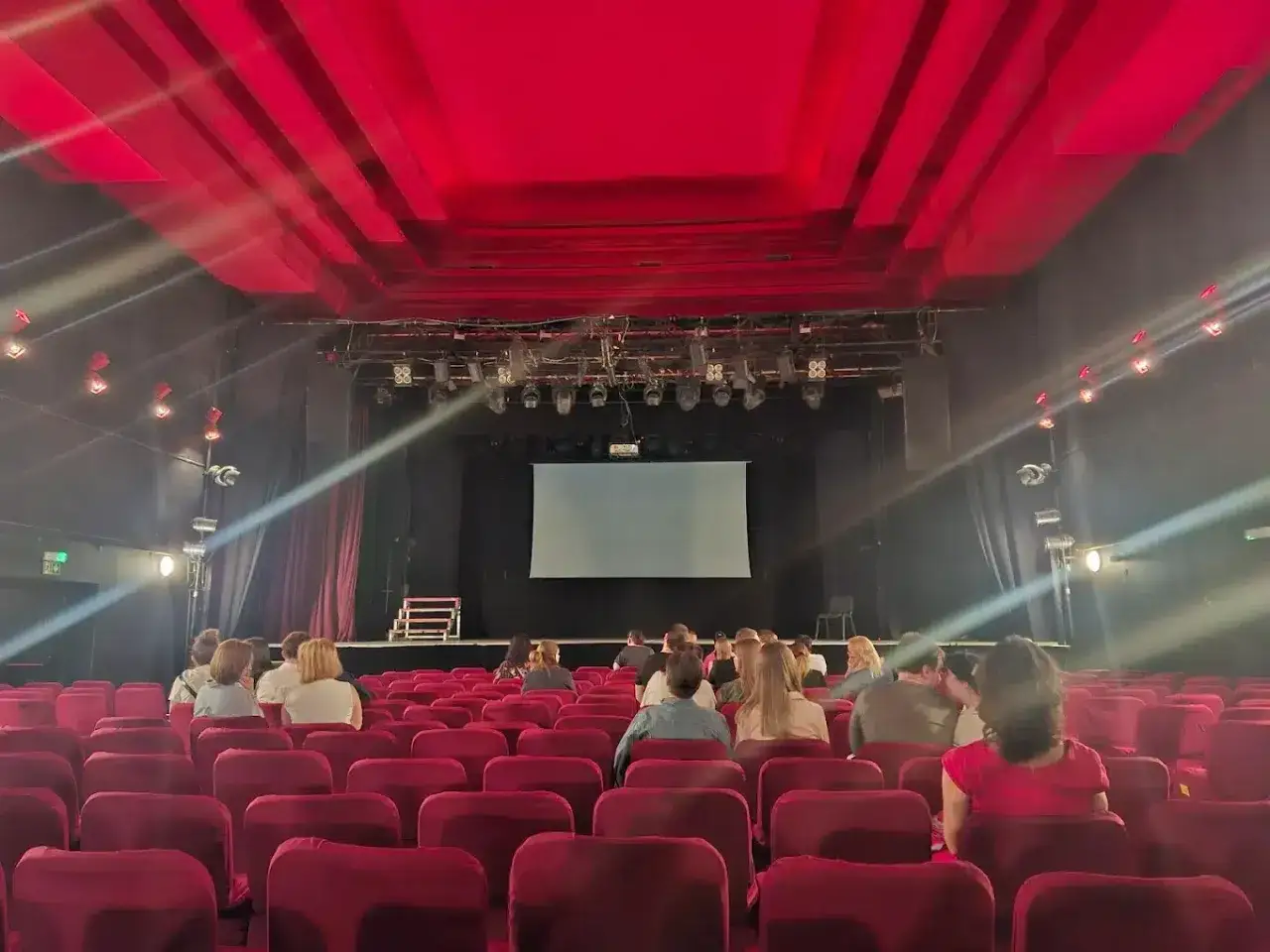 Widownia Teatru Palladium z czerwonymi fotelami i sceną. Widok z perspektywy widza, plan widowni.