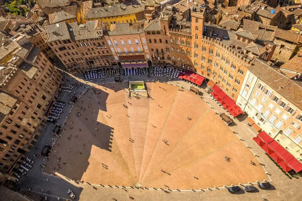 Vista aerea della **Piazza del Campo** di Siena, con i suoi edifici storici e la caratteristica forma a conchiglia.