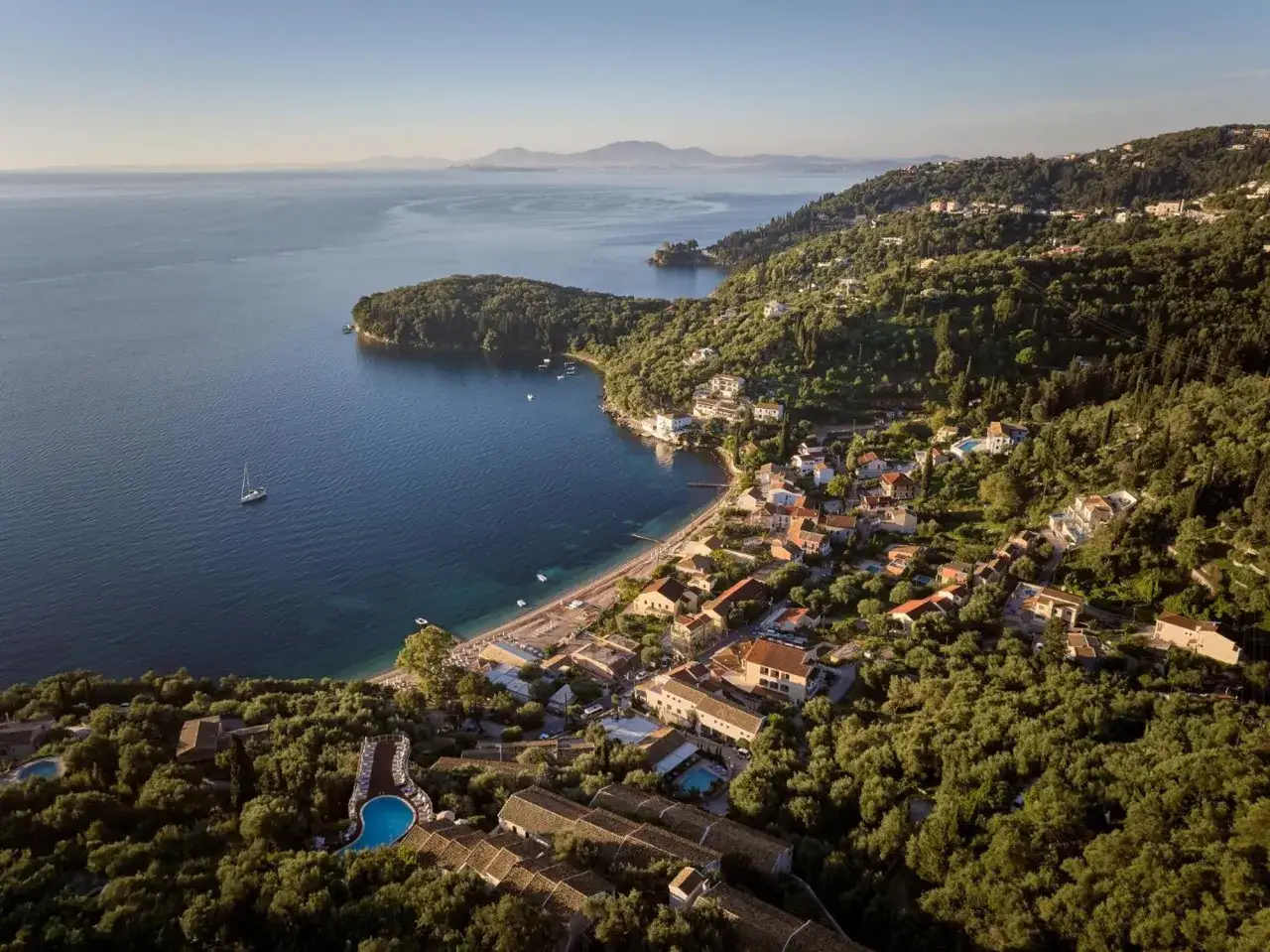 Traumhafter Alkyna Lifestyle Beach Resort mit Pool und Blick aufs Meer, eingebettet in grüne Hügel.