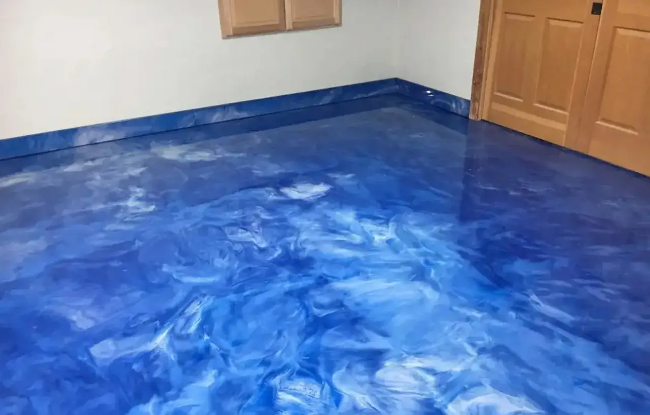 Pavimento lucido blu effetto marmo, che illustra la differenza tra resina epossidica e poliuretanica per un look moderno.