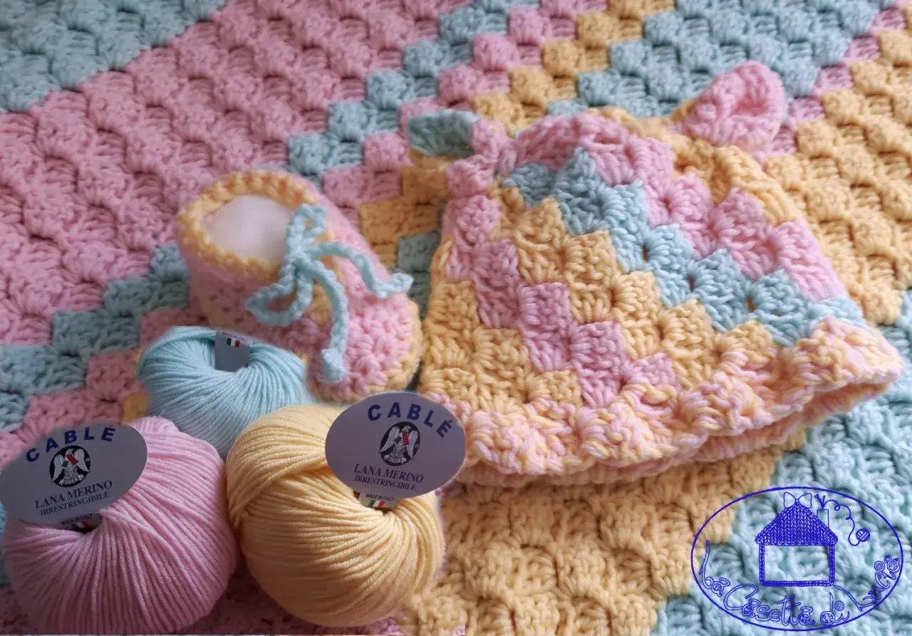 Uncinetto per bambini: schemi gratis per creare scarpine e cappellino in lana merino, con gomitoli color pastello.