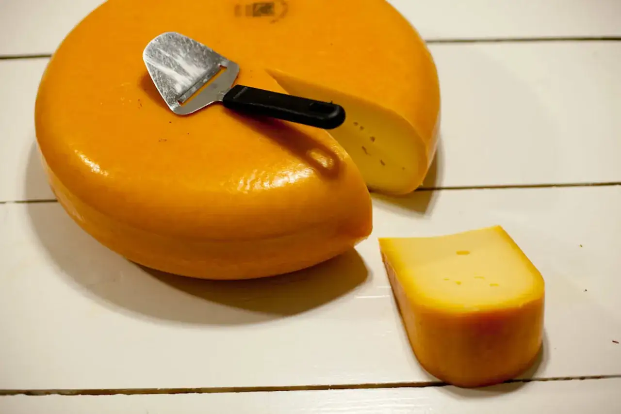 Queso redondo y una cu&ntilde;a, con un cortador. &iexcl;Qu&eacute; rico! Se puede comer la corteza del queso, es parte del sabor.