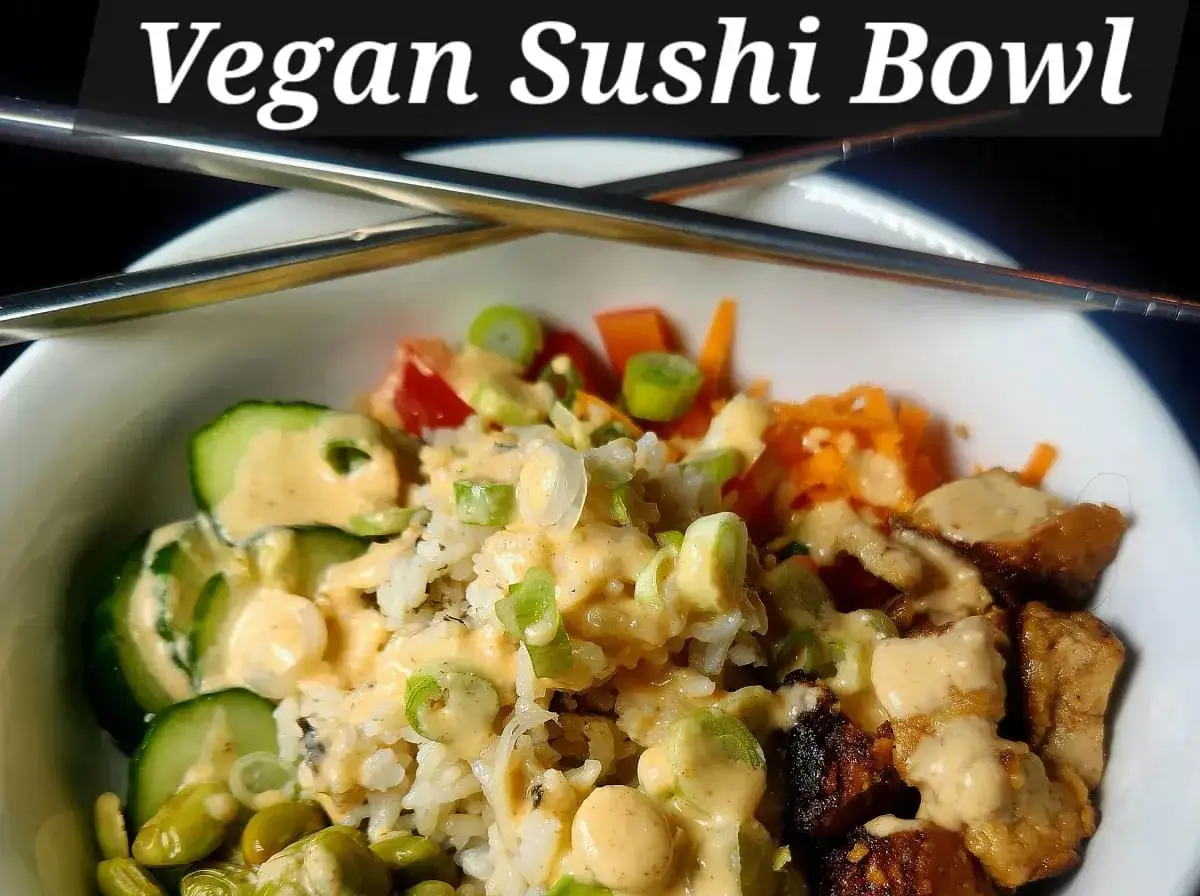 Eine k&ouml;stliche vegan sushi bowl mit Reis, Gurke, Edamame, Karotten und Tofu, betr&auml;ufelt mit cremiger Sauce.