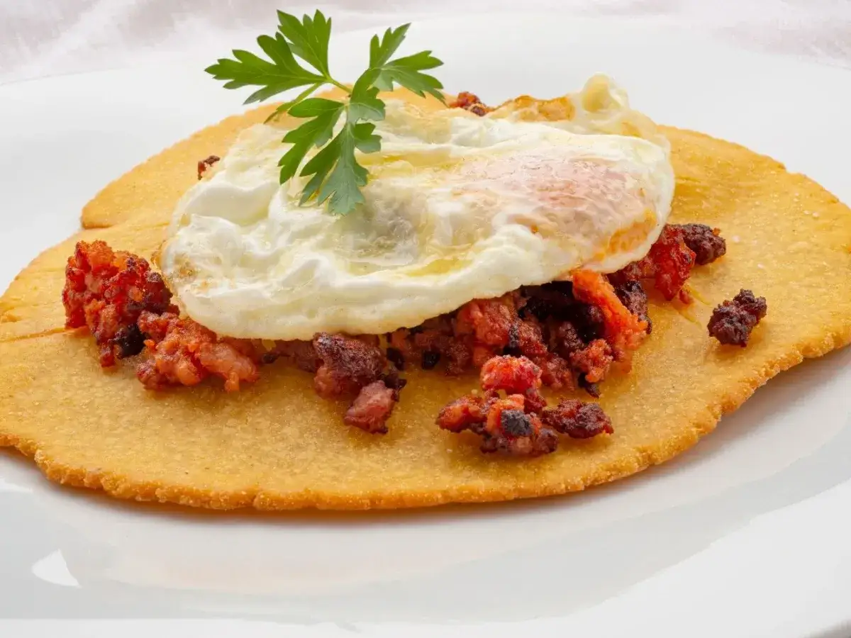 Tortos asturianos con huevo frito y chorizo. Un plato tradicional asturiano, crujiente y sabroso.