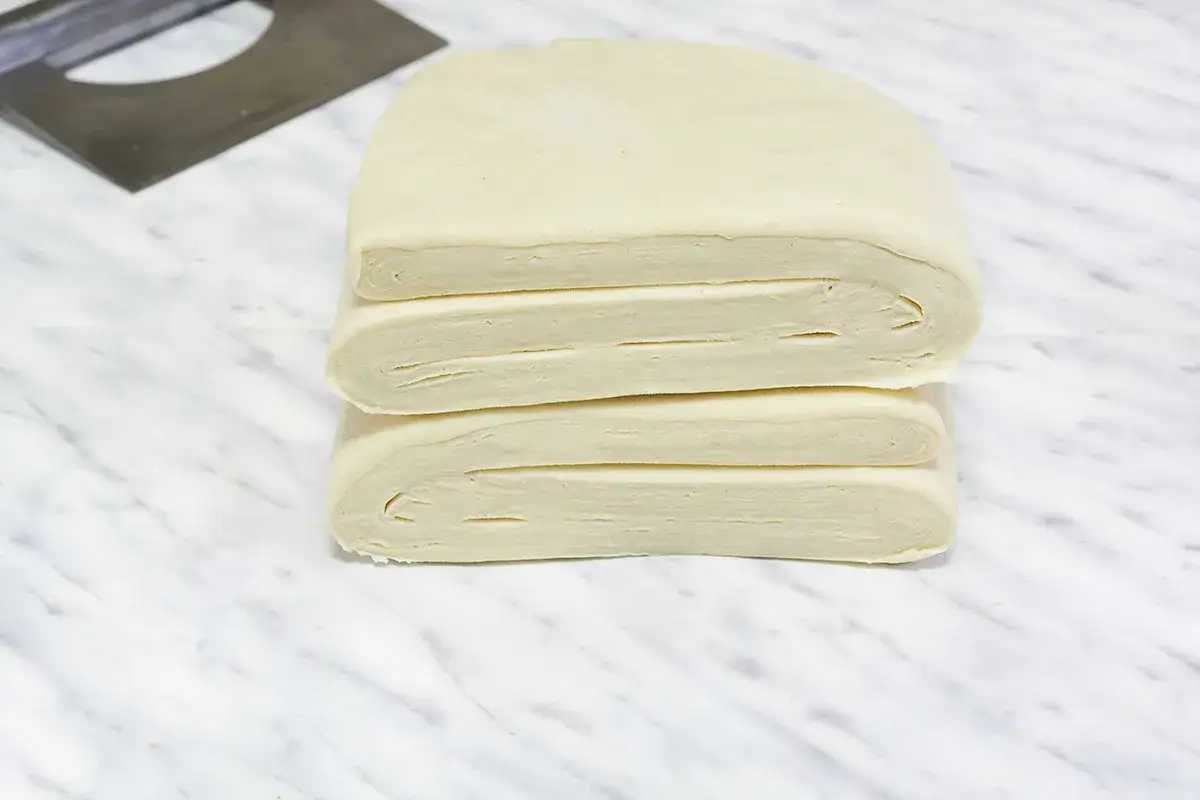 Masa hojaldre apilada, mostrando sus capas. Lista para crear deliciosos pasteles.