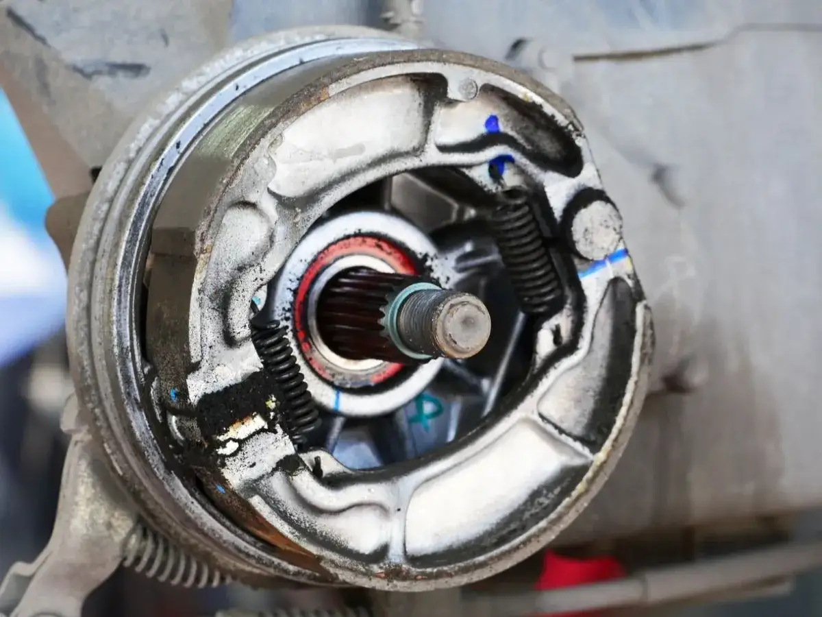 Detalle del freno de tambor de motocicleta, mostrando las zapatas desgastadas y el tambor interno.