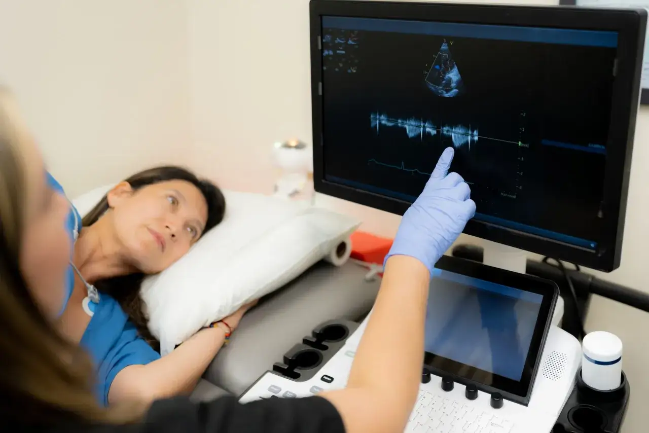 Une &eacute;chographie cardiaque montre un souffle systolique. Le m&eacute;decin explique le r&eacute;sultat &agrave; la patiente.