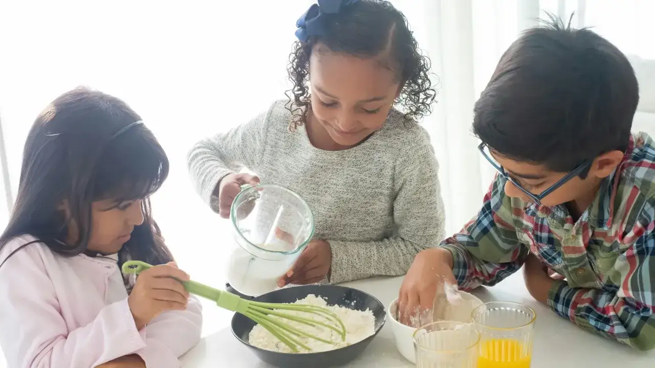 Ni&ntilde;os preparando chuches saludables para ni&ntilde;os, mezclando ingredientes para hornear.