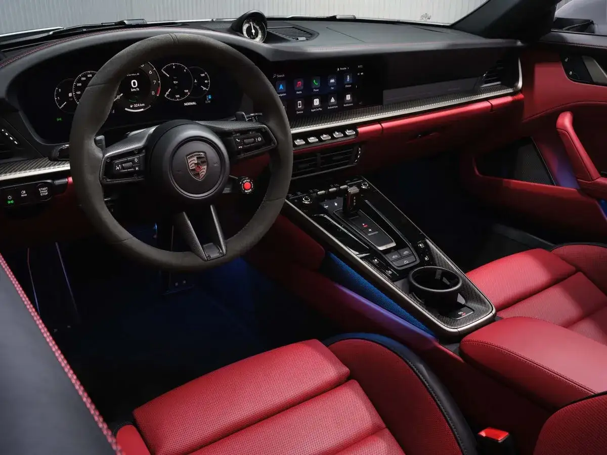 Wnętrze Porsche 911 Turbo S z czerwonymi skórzanymi fotelami i sportową kierownicą.