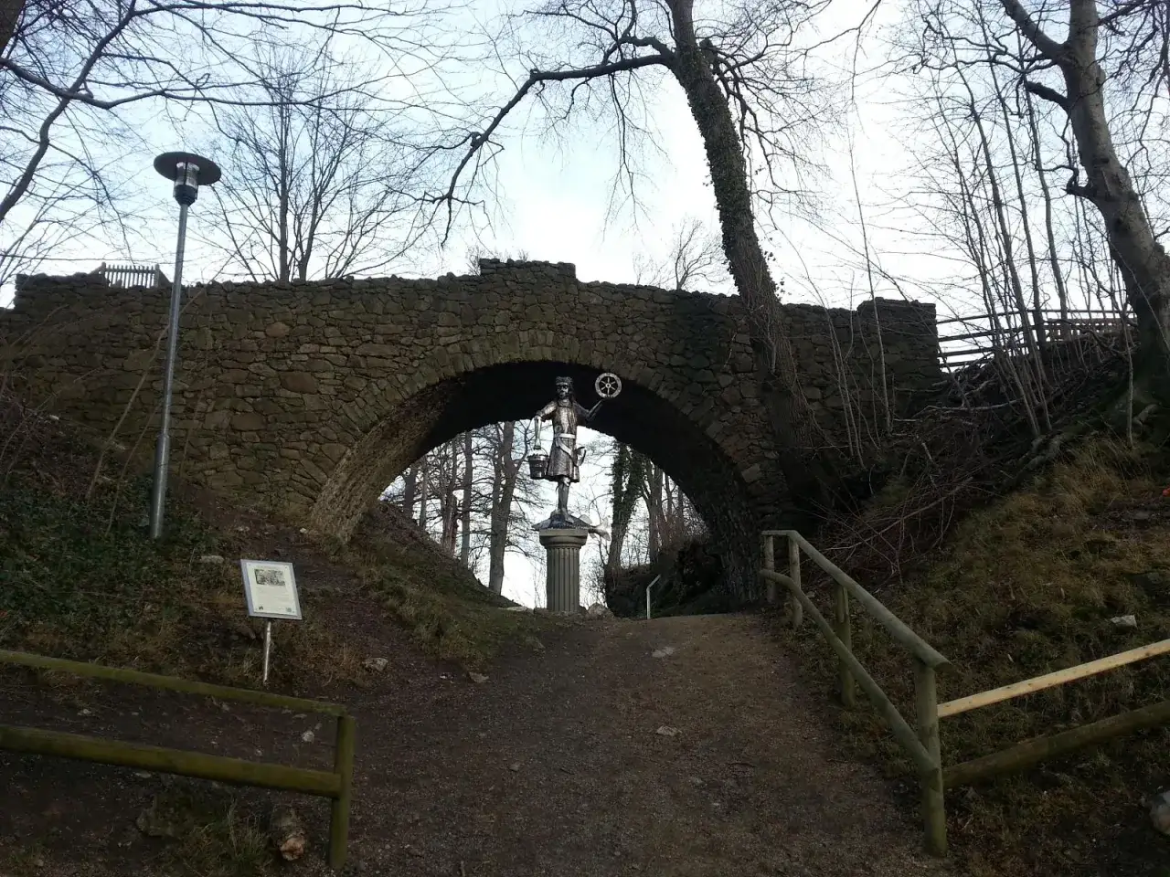 Ein geheimtipp Bad Harzburg: Eine Steinbr&uuml;cke mit einer Statue eines M&auml;dchens, das einen Eimer und ein Rad h&auml;lt.