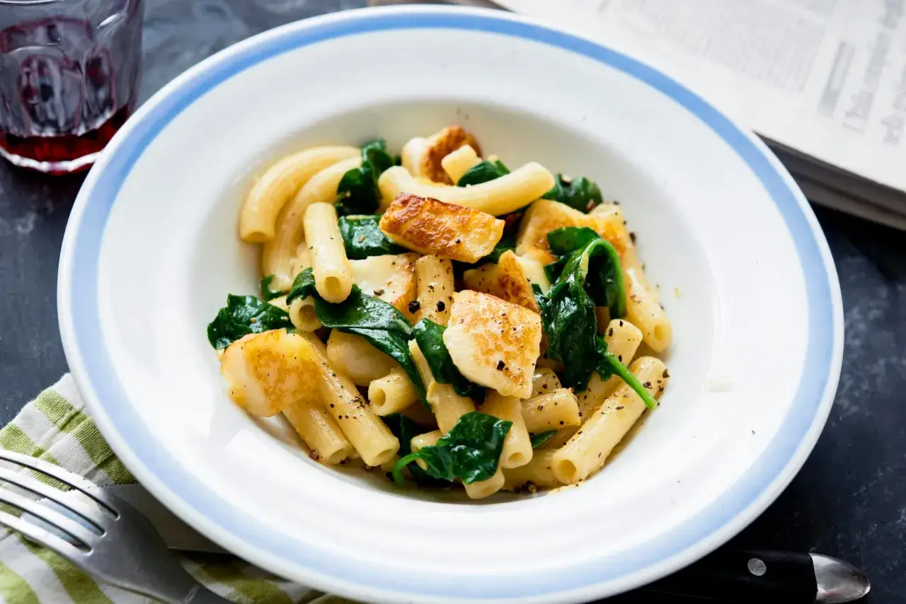 En tallrik med halloumi pasta och spenat, kryddad med peppar. Enkelt och gott!