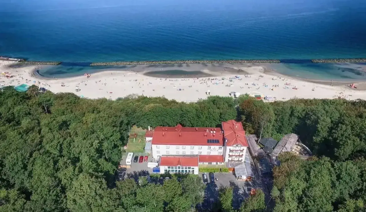 Idealne darłówek noclegi blisko morza. Hotel otoczony lasem, z widokiem na piaszczystą plażę i błękitne morze.