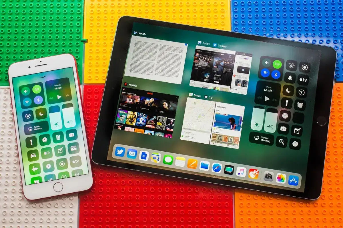 iPhone i iPad z interfejsem iOS 11 na kolorowym tle z klocków.
