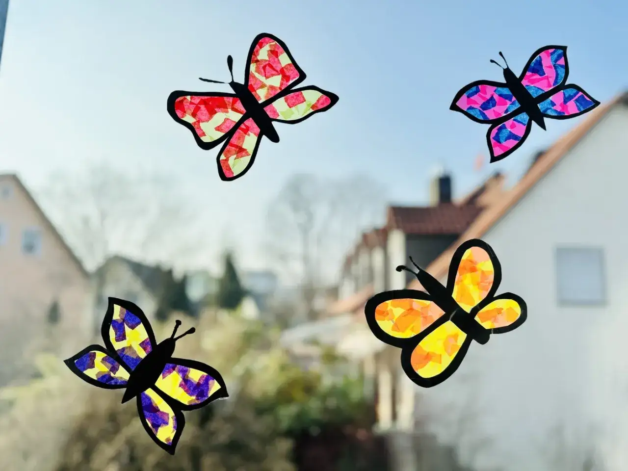 Bunte Schmetterlinge aus Seidenpapier, ein tolles Projekt f&uuml;r Fensterfolie basteln Kinder. Sie schm&uuml;cken das Fenster mit leuchtenden Farben.