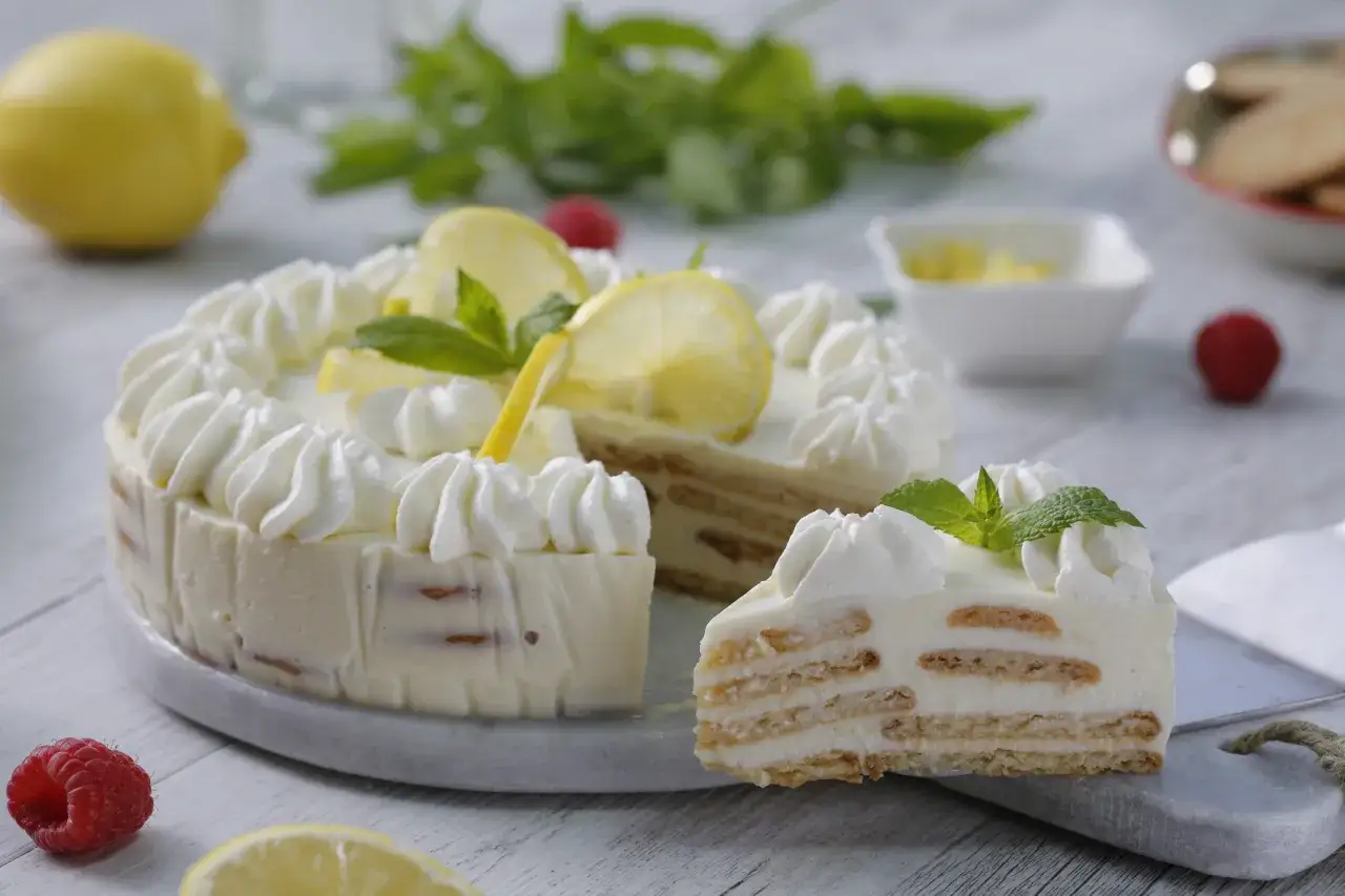Deliciosa crostata al limone con crema y merengue, decorada con rodajas de limón y menta.