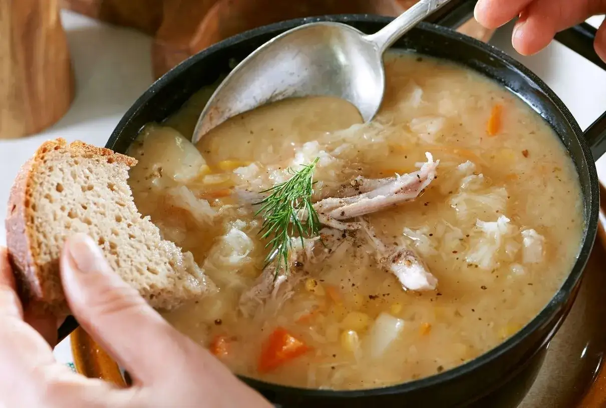 Pyszna zupa z wywaru po golonce, z kawałkami mięsa, warzywami i chlebem. Idealna na chłodne dni.