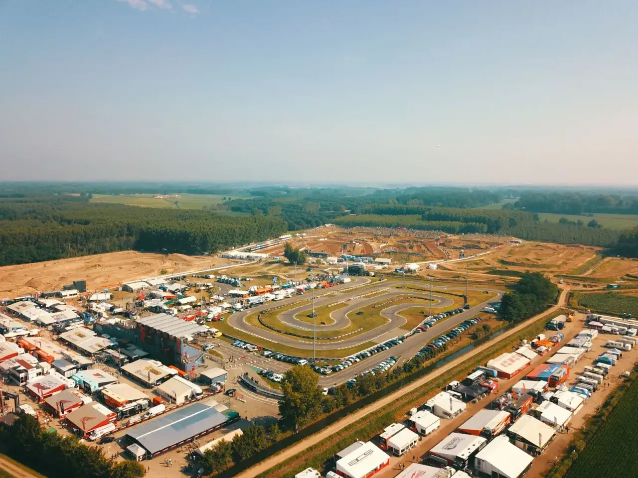 Vista aerea di un circuito **ottobiano motorsport** con paddock, tribune e pista da cross sullo sfondo.