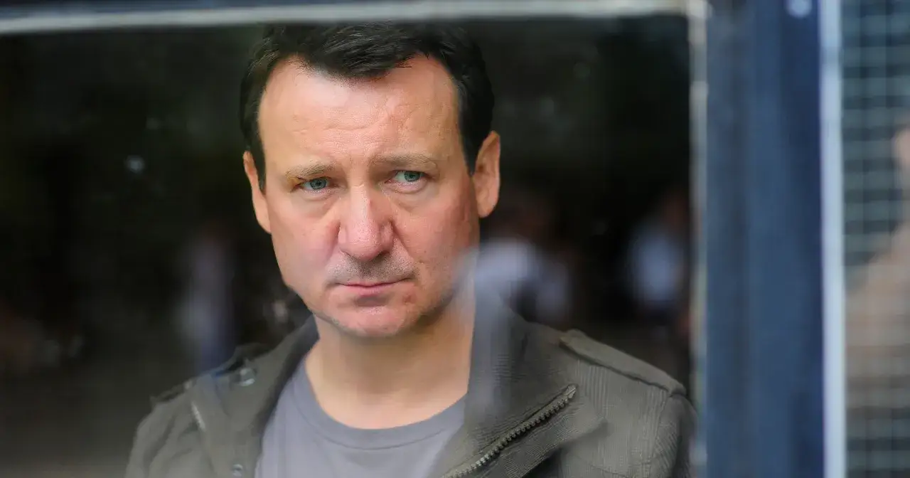 Robert Więckiewicz, znany z wielu filmów, seriali i programów, patrzy zza szyby.