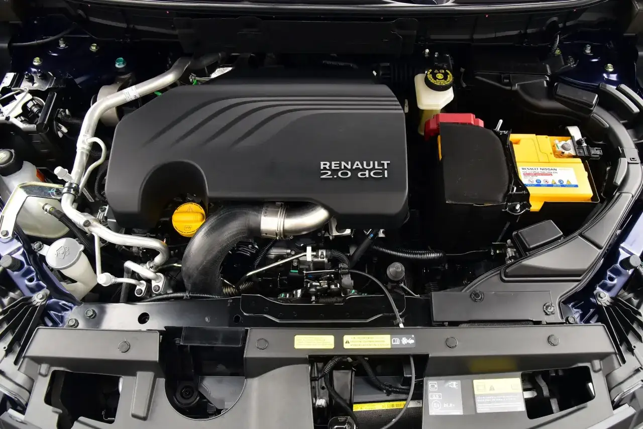 Silnik Renault Koleos 2.0 dCi z widoczną turbosprężarką, akumulatorem i innymi elementami komory silnika.