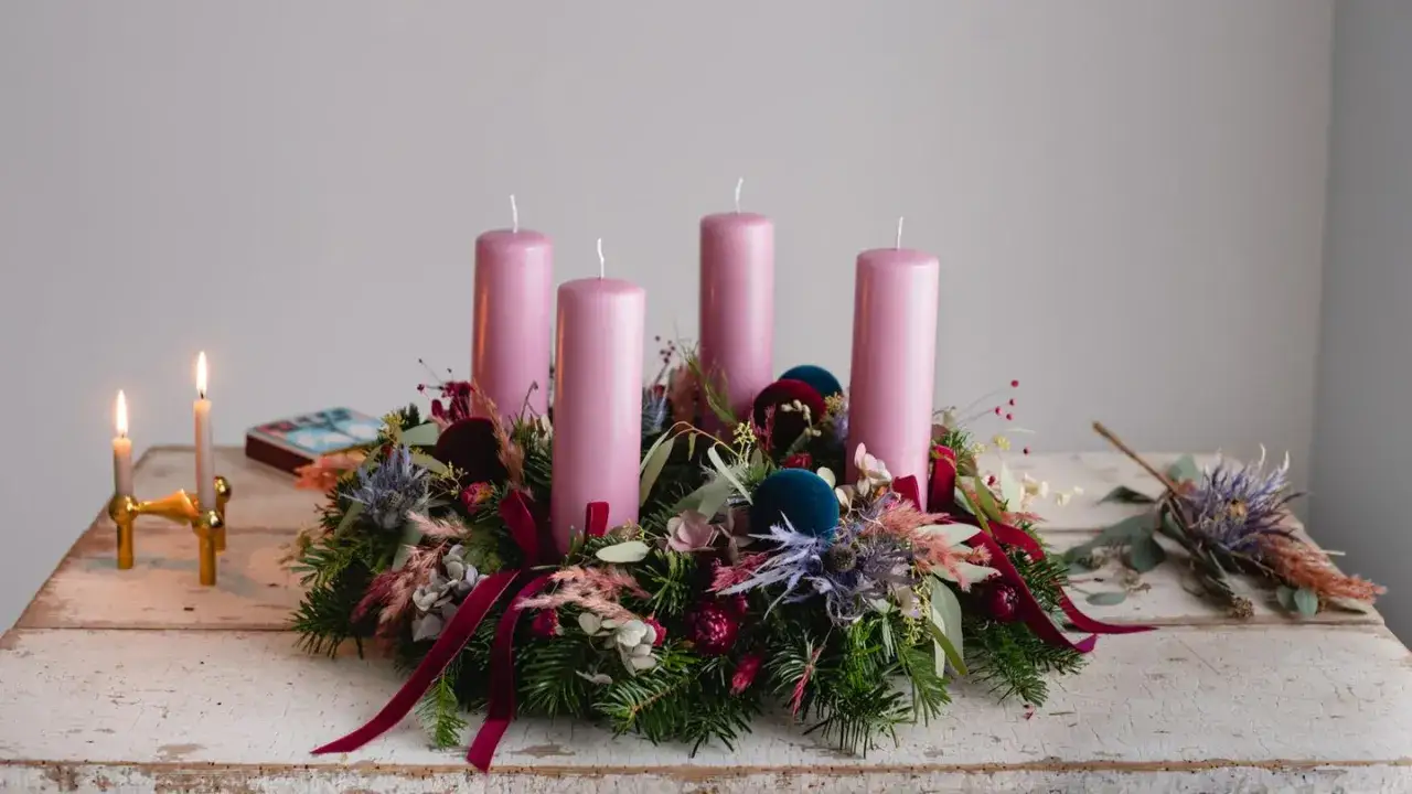 Ein wundersch&ouml;ner Adventskranz natur selber machen: vier rosa Kerzen auf Tannengr&uuml;n, dekoriert mit Trockenblumen und Samtband.