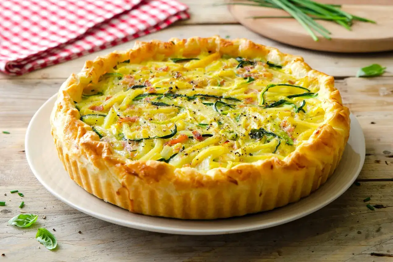 Torta salata con zucchine e pancetta, dorata e invitante, pronta per essere gustata.
