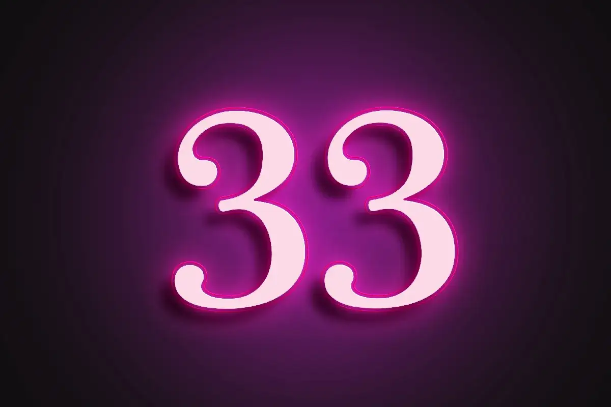 Jasnoróżowe cyfry 33 z neonowym obramowaniem na fioletowym tle. 33 liczba mistrzowska.