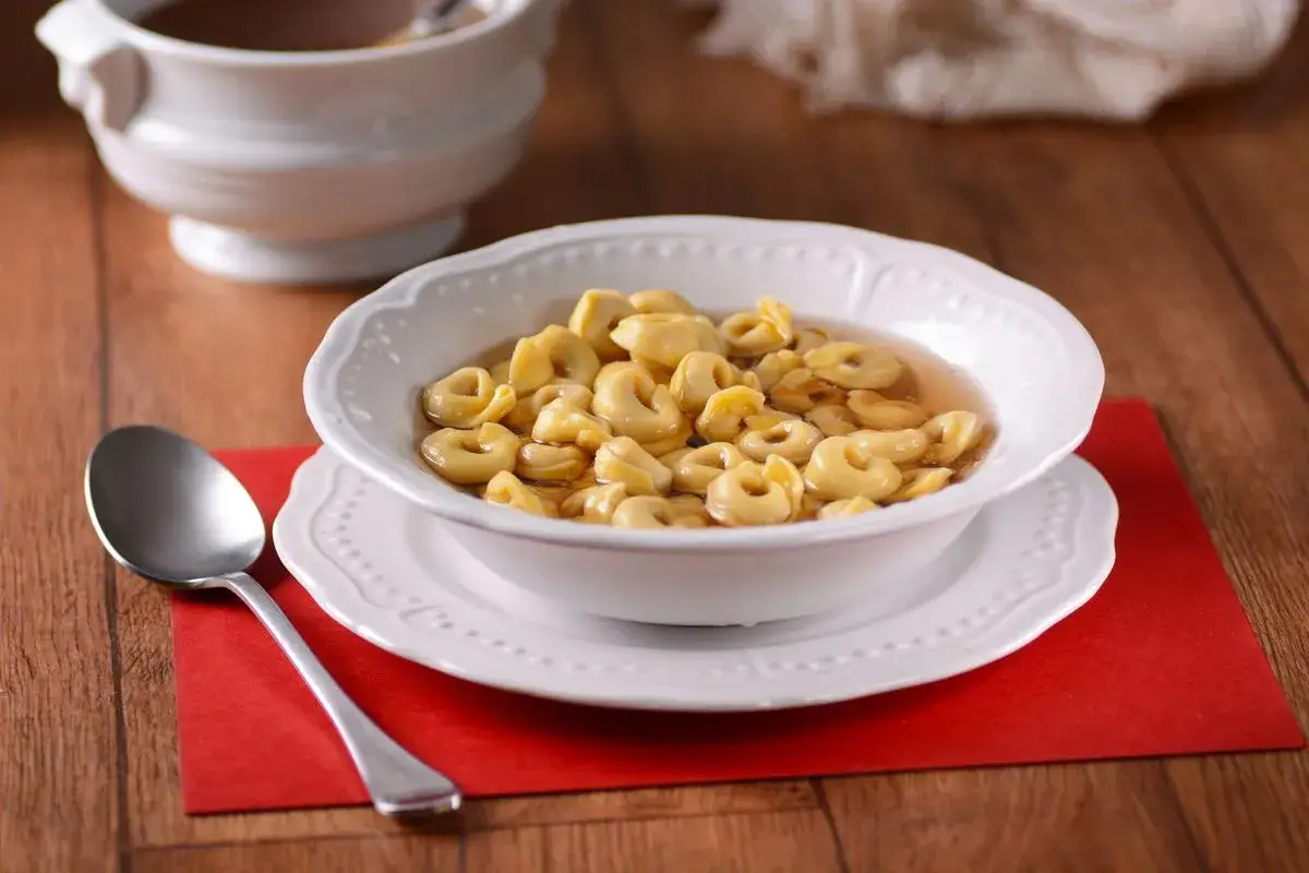 Un piatto fumante di tortellini in brodo, un classico confortante, pronto per essere gustato.