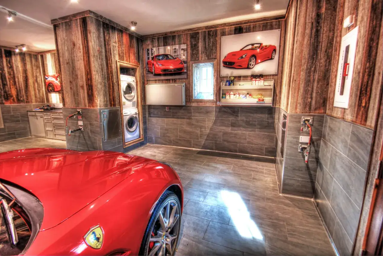 Un garage con un'auto rossa, lavatrice e quadri di auto. Perfetto per chi pensa di che colore pitturare il garage e ama le rosse.