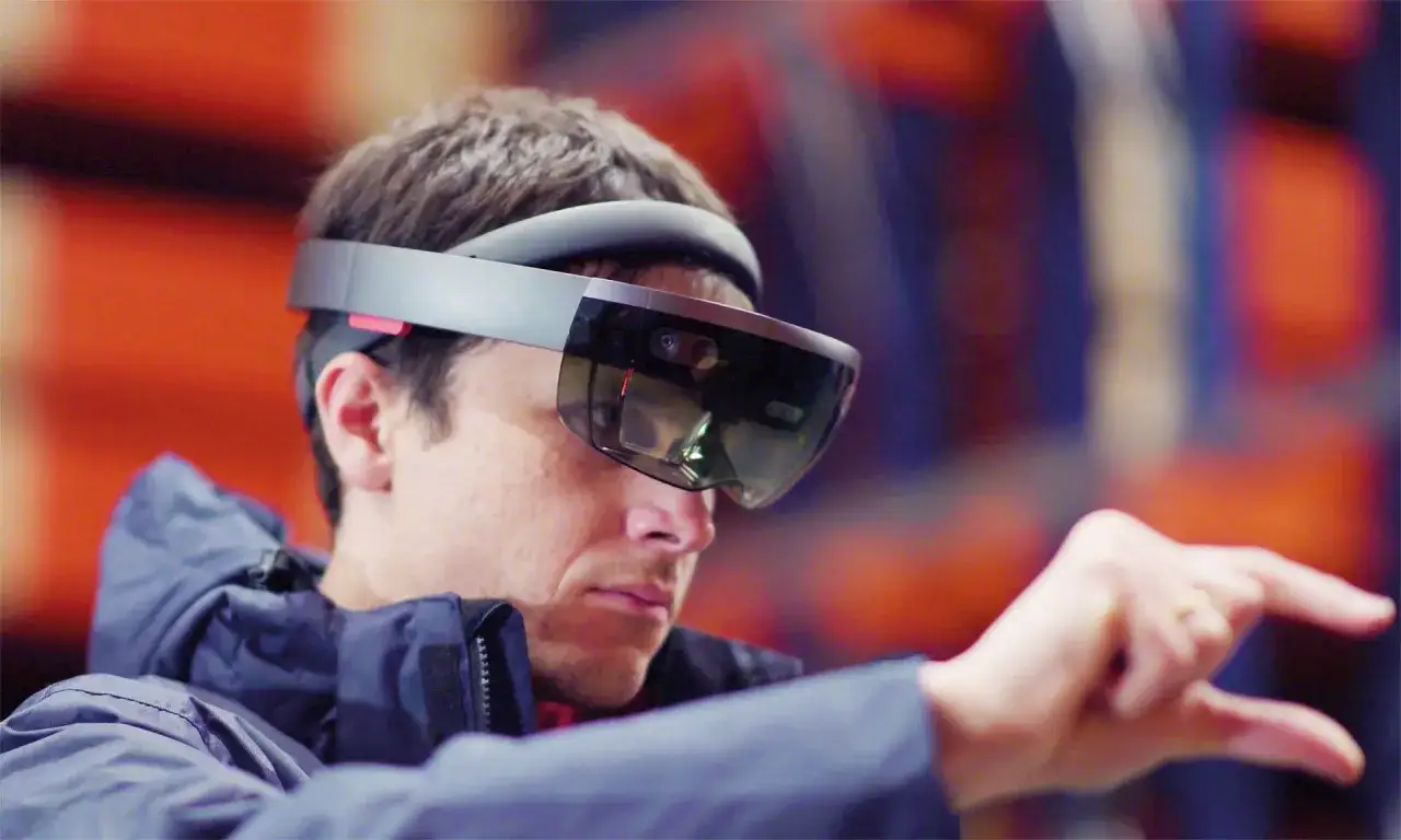 Mężczyzna w goglach VR, kt&oacute;ry dzięki technologii **pick by vision** wybiera obiekty w przestrzeni.