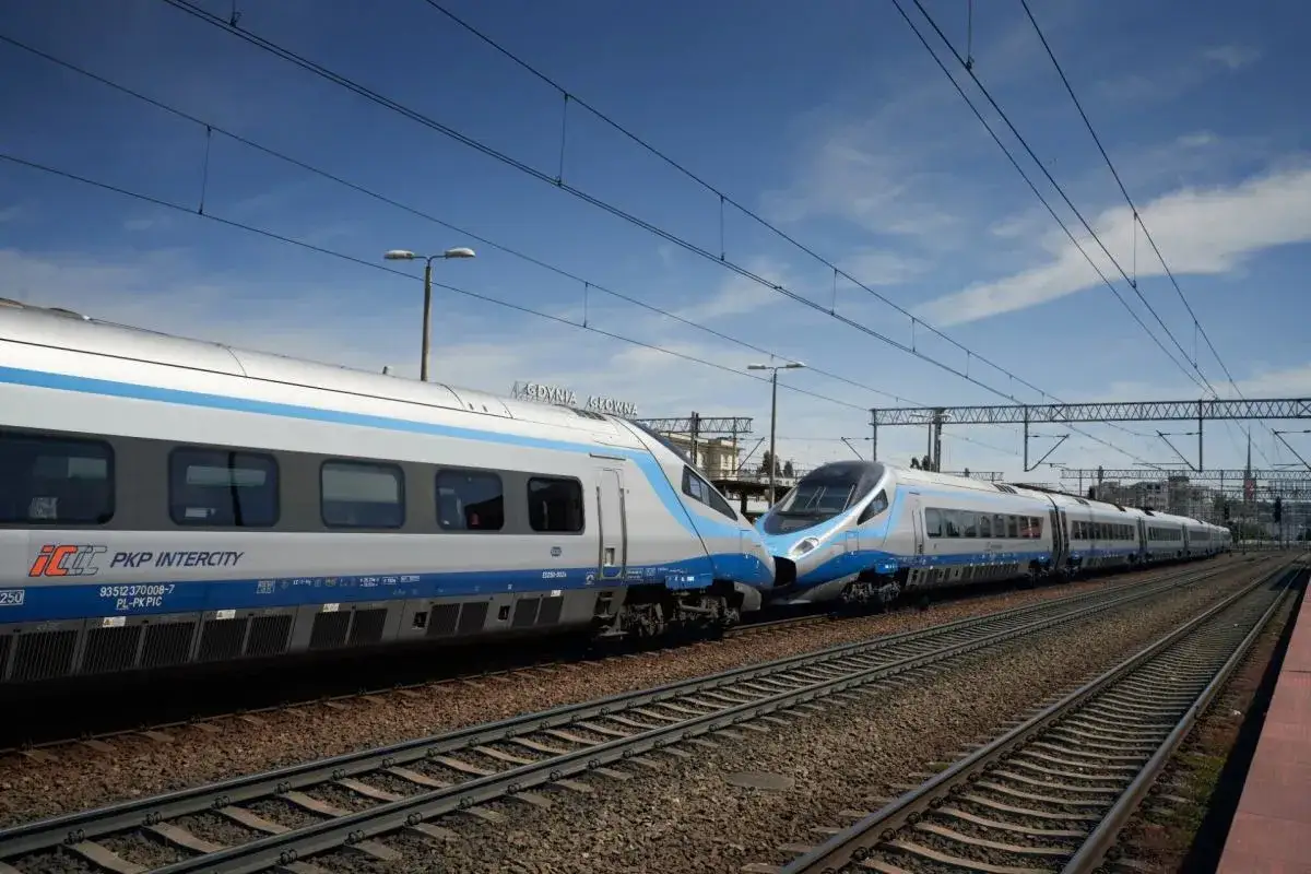 Dwa pociągi Pendolino PKP Intercity stoją obok siebie na torach. Jeden z nich ma skrót 
