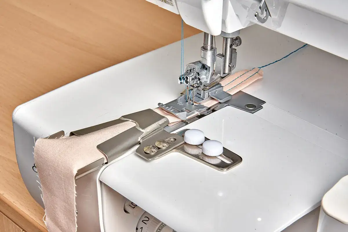Sewing machine with a guide attachment for creating various types of belt loops on fabric.
