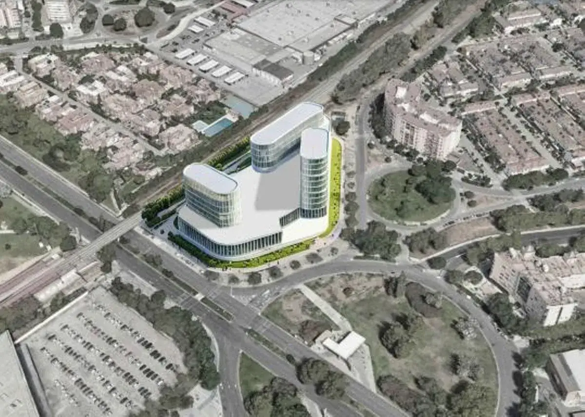 Vista a&eacute;rea de un moderno edificio de oficinas con fachadas curvas, rodeado de zonas verdes y urbanizaciones. El **suelo terciario** se integra con v&iacute;as de comunicaci&oacute;n y aparcamientos.