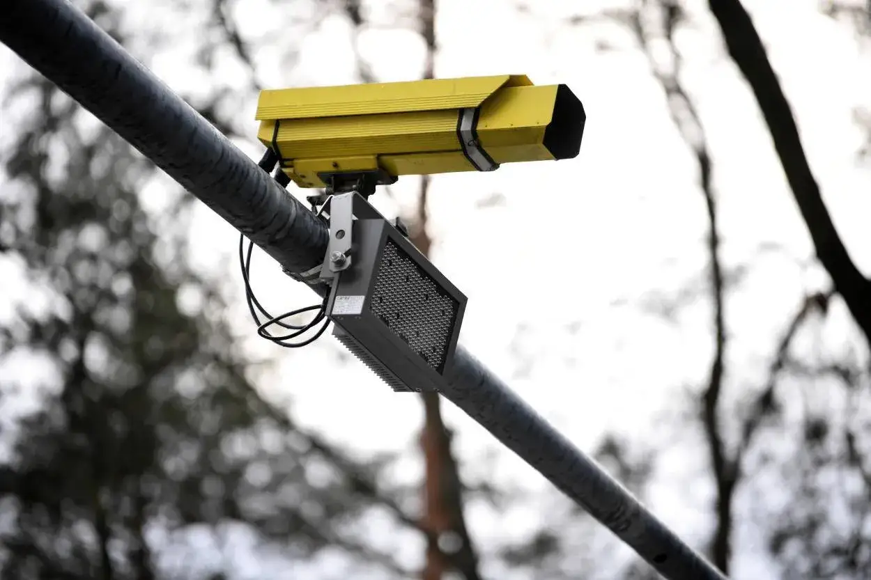 Żółta kamera monitorująca zamontowana na słupie, kontrolująca odcinkowe pomiary prędkości na A4.