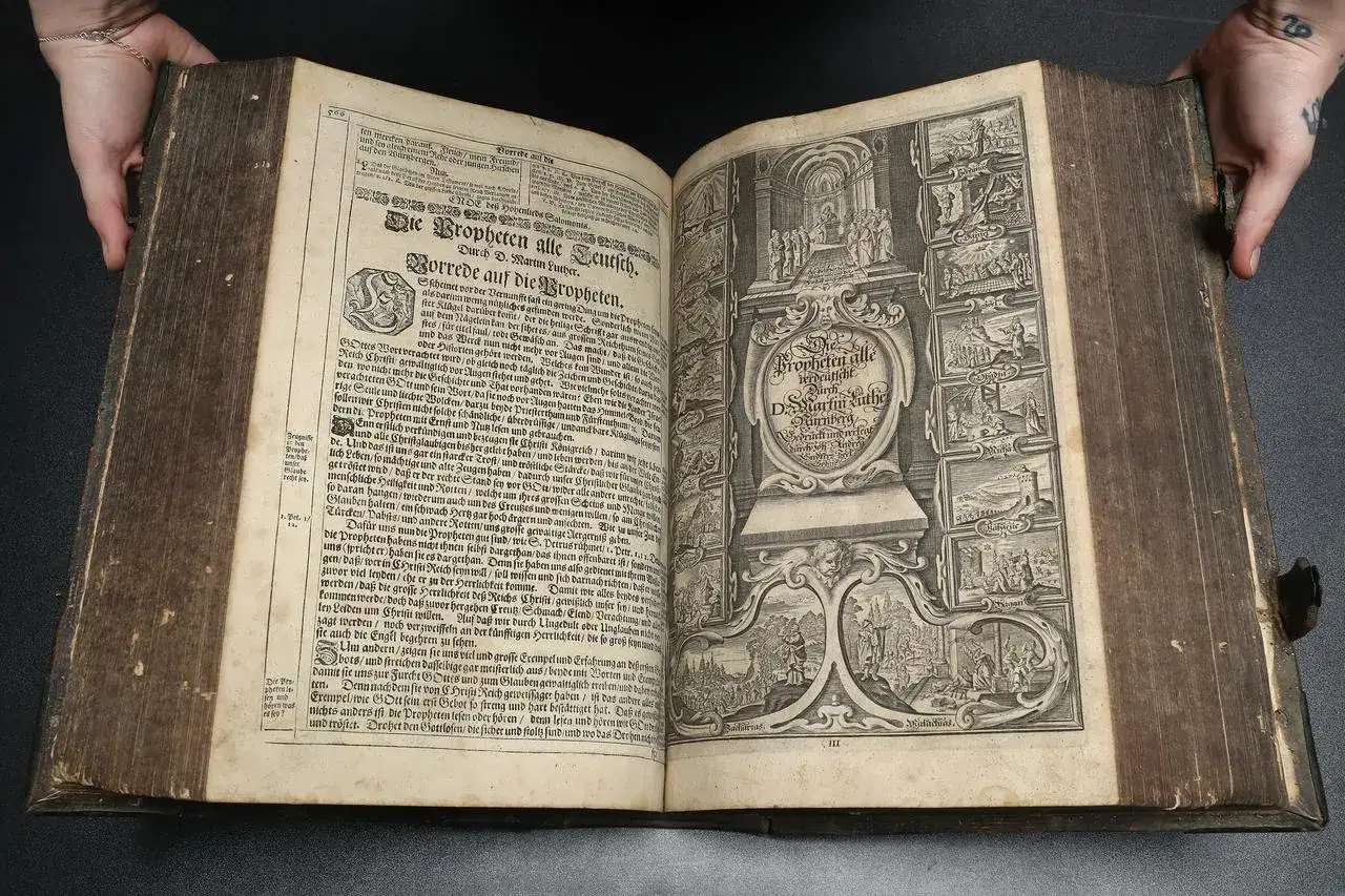 Alte Lutherbibel mit Holzschnitten, die den Unterschied zwischen der Lutherbibel und der katholischen Bibel verdeutlichen.