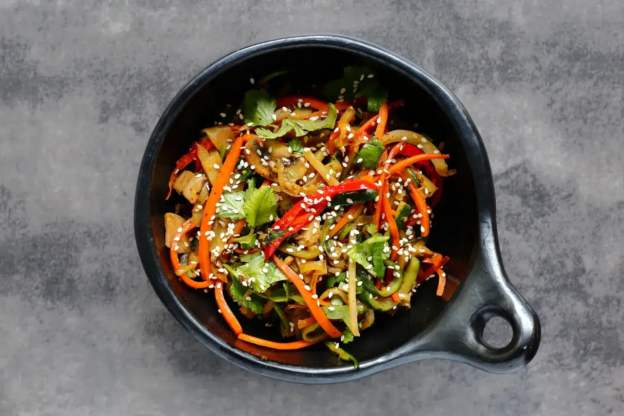 Kolorowy stir-fry z marchewką, cukinią i papryką, posypany sezamem. Idealny przepis na szybki obiad.