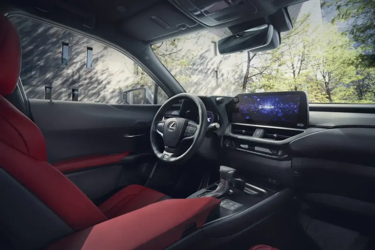 Wnętrze Lexus UX 200 z czerwonymi skórzanymi fotelami i nowoczesnym ekranem multimedialnym.