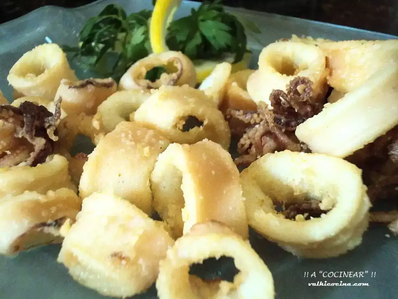 Calamares a la andaluza crujientes y dorados, servidos con perejil y limón. ¡Un clásico irresistible!