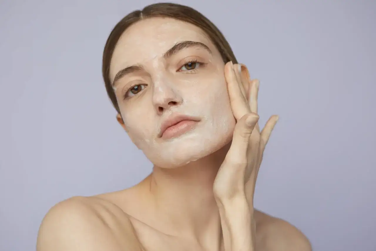Donna applica una maschera viso. L'acido tartarico a cosa serve? Aiuta a esfoliare e illuminare la pelle.