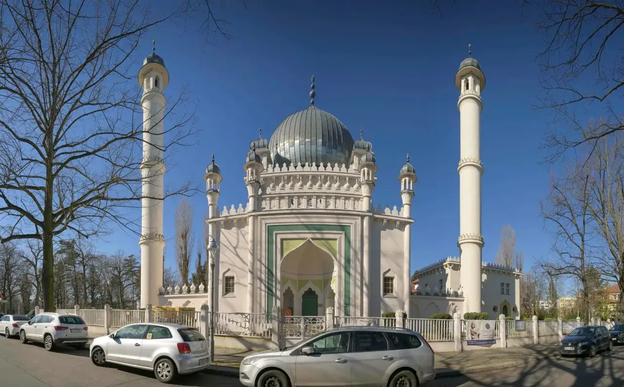 Die Moschee in Charlottenburg-Wilmersdorf mit ihren Minaretten und Kuppeln, davor parkende Autos.