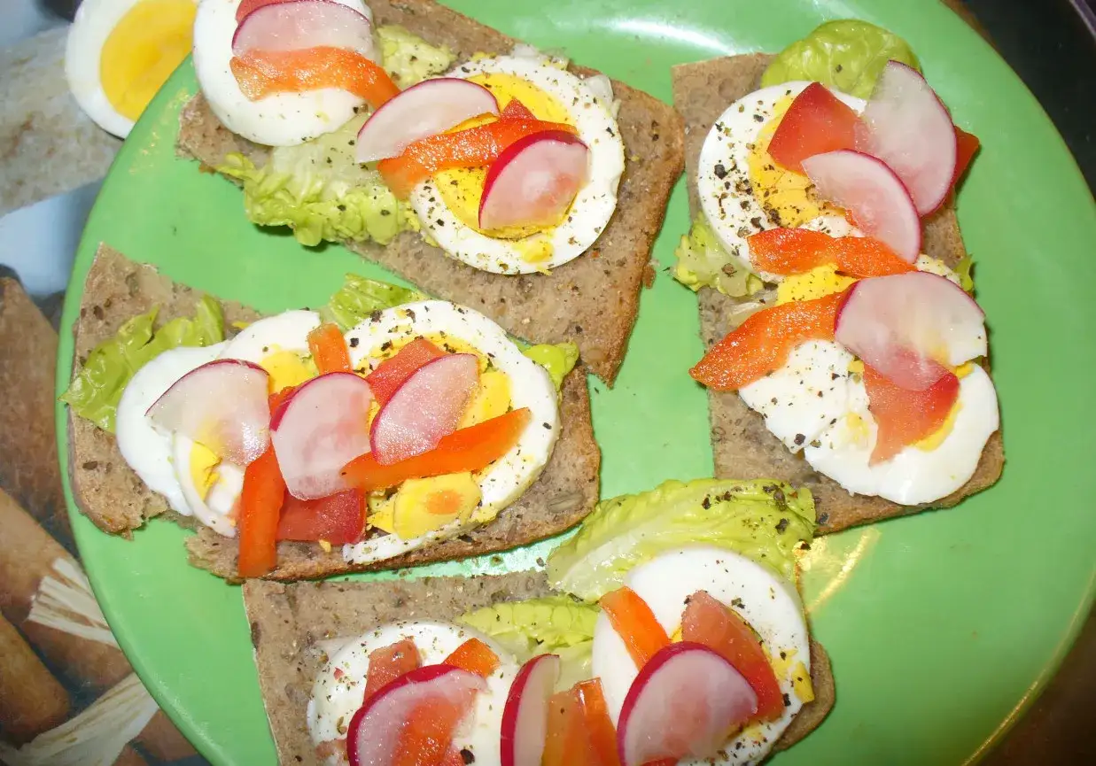 Pyszne kanapki z jajkiem, rzodkiewką i papryką na ciemnym pieczywie. Idealne na szybkie śniadanie lub przekąskę.
